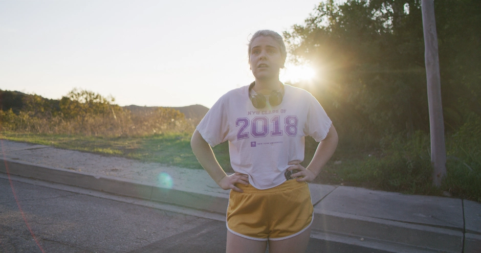 Our character breathes heavily at the top of a hill in front of the sunset, after struggling to run up the hill.