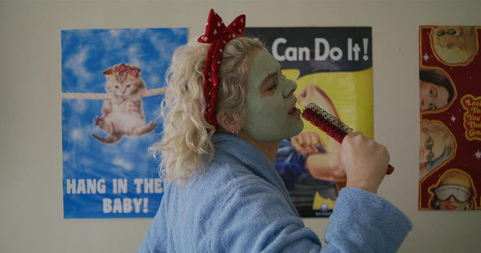 Our character mimes singing into a hairbrush as she performs past various posters on the wall behind her.