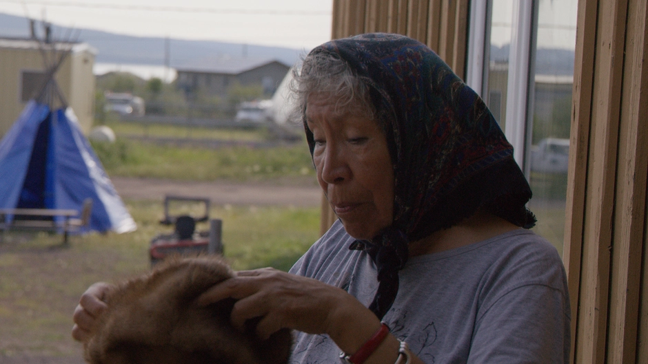 An elder examines art that she has made